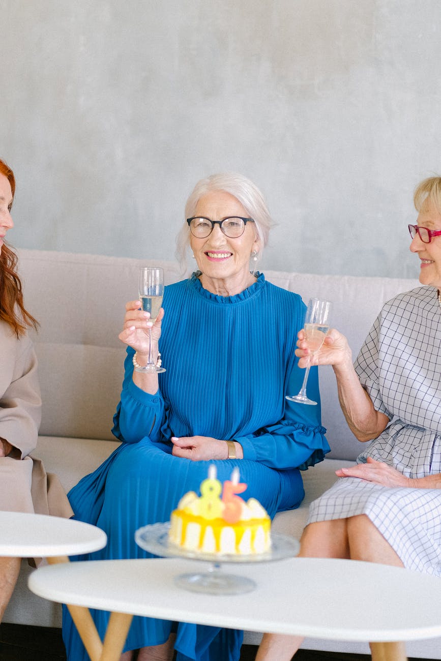 happy aged women with glasses of champagne smiling